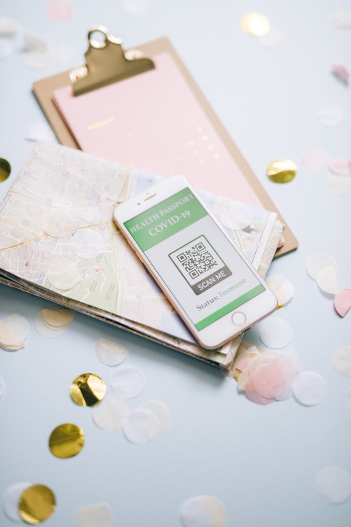 Smartphone displaying COVID-19 health passport on a map with confetti.